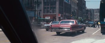 Movie still from “Dirty Harry” (1971), directed by Don Siegel – Two cars are driving down the street in a city; Wide shot, Over the shoulder angle