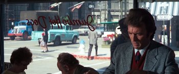 Movie still from “Dirty Harry” (1971), directed by Don Siegel – Two men are standing in front of a street sign; Medium shot, Over the shoulder angle