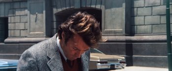 Movie still from “Dirty Harry” (1971), directed by Don Siegel – A person wearing a suit and tie; Close Up shot, Low angle