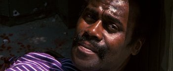 Movie still from “Dirty Harry” (1971), directed by Don Siegel – A person wearing a purple shirt; Close Up shot, Low angle