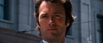 Movie still from “Dirty Harry” (1971), directed by Don Siegel – A man's face in a suit and tie; Close Up shot, Low angle