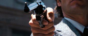 Movie still from “Dirty Harry” (1971), directed by Don Siegel – A person holding a gun in their hand; Close Up shot, Low angle