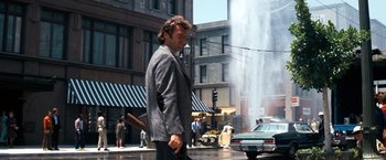 Movie still from “Dirty Harry” (1971), directed by Don Siegel – A man walking down the street in a suit and tie; Wide shot, Low angle