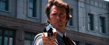 Movie still from “Dirty Harry” (1971), directed by Don Siegel – A person holding a gun; Close Up shot, Low angle