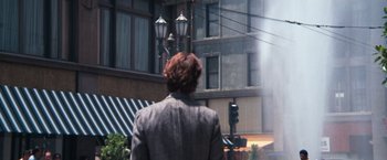 Movie still from “Dirty Harry” (1971), directed by Don Siegel – A person standing on a sidewalk near a street light; Wide shot, Over the shoulder angle