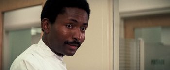 Movie still from “Dirty Harry” (1971), directed by Don Siegel – A person wearing a white shirt; Close Up shot, Low angle