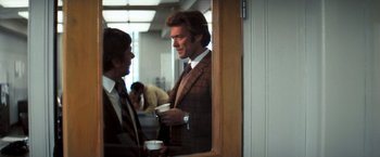 Movie still from “Dirty Harry” (1971), directed by Don Siegel – A man in a suit talking to another man in a tie; Medium shot, Over the shoulder angle