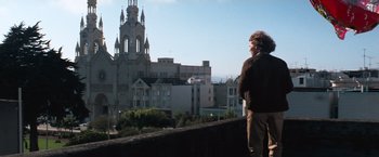 Movie still from “Dirty Harry” (1971), directed by Don Siegel – A man standing on a balcony looking out at a building; Wide shot, Low angle