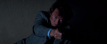 Movie still from “Dirty Harry” (1971), directed by Don Siegel – A man in a suit pointing a gun at the camera; Close Up shot, Low angle