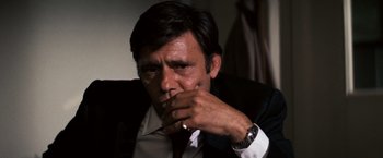 Movie still from “Dirty Harry” (1971), directed by Don Siegel – A person wearing a suit and tie; Close Up shot, Low angle