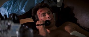 Movie still from “Dirty Harry” (1971), directed by Don Siegel – A man with a bandaged face talking on a phone; Close Up shot, High angle