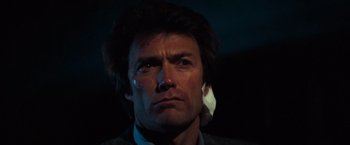 Movie still from “Dirty Harry” (1971), directed by Don Siegel – A person wearing a suit and tie; Close Up shot, Low angle