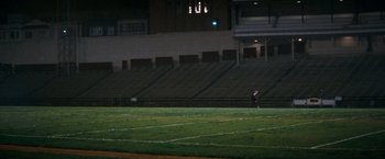 Movie still from “Dirty Harry” (1971), directed by Don Siegel – A person standing on a soccer field at night; Extreme Wide shot, High angle