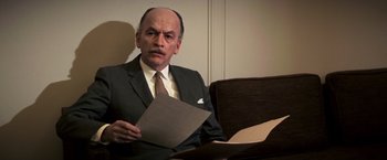 Movie still from “Dirty Harry” (1971), directed by Don Siegel – A man in a suit and tie holding a piece of paper; Close Up shot, Low angle