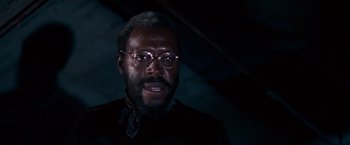 Movie still from “Dirty Harry” (1971), directed by Don Siegel – A man with a beard wearing glasses and a black shirt; Close Up shot, Low angle