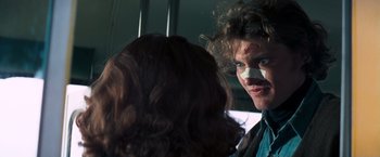 A man with a bandage on his face looking at a woman with a bandage on her face