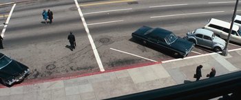 Movie still from “Dirty Harry” (1971), directed by Don Siegel – A man standing on the side of a road next to a car; Extreme Wide shot, High angle