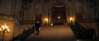 Movie still from “Dirty Harry” (1971), directed by Don Siegel – A man in a suit standing in front of a staircase; Extreme Wide shot, High angle