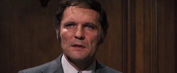 Movie still from “Dirty Harry” (1971), directed by Don Siegel – A person wearing a suit and tie; Close Up shot, Over the shoulder angle