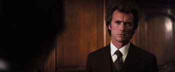 Movie still from “Dirty Harry” (1971), directed by Don Siegel – A person wearing a suit and tie; Close Up shot, Low angle