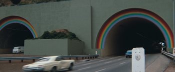 Movie still from “Dirty Harry” (1971), directed by Don Siegel – A car driving down a street under a rainbow; Extreme Wide shot, High angle