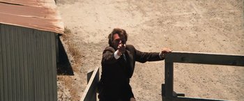 Movie still from “Dirty Harry” (1971), directed by Don Siegel – A man in a suit and tie pointing a gun at the camera; Medium shot, Low angle
