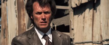 Movie still from “Dirty Harry” (1971), directed by Don Siegel – A person wearing a suit and tie; Close Up shot, Low angle