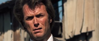 Movie still from “Dirty Harry” (1971), directed by Don Siegel – A person wearing a suit and tie; Close Up shot, Low angle