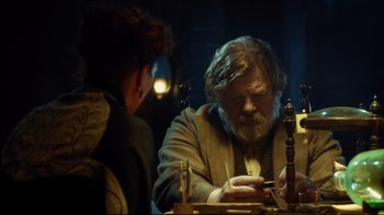 Movie still from “In the Heart of the Sea” (2015), directed by Ron Howard – An older man sitting at a table with a young boy; Medium shot, Low angle