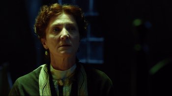 Movie still from “In the Heart of the Sea” (2015), directed by Ron Howard – An older woman with red curly hair wearing a green sweater; Close Up shot, Low angle