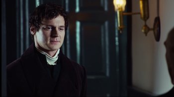 Movie still from “In the Heart of the Sea” (2015), directed by Ron Howard – A man in a black suit standing in front of a door; Close Up shot, Over the shoulder angle