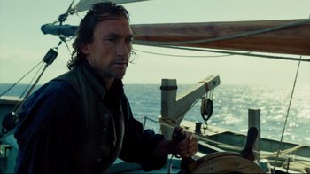 Movie still from “In the Heart of the Sea” (2015), directed by Ron Howard – A man on a sailboat in the water; Close Up shot, Over the shoulder angle
