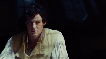 Movie still from “In the Heart of the Sea” (2015), directed by Ron Howard – A man in a yellow shirt is looking at the camera; Close Up shot, Over the shoulder angle