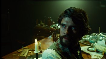 Movie still from “In the Heart of the Sea” (2015), directed by Ron Howard – A man sitting at a table with a candle in front of him; Close Up shot, Over the shoulder angle