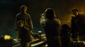 Movie still from “In the Heart of the Sea” (2015), directed by Ron Howard – A group of people standing next to each other in the dark; Wide shot, Over the shoulder angle