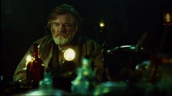 Movie still from “In the Heart of the Sea” (2015), directed by Ron Howard – An older man sitting in front of a table; Medium shot, Over the shoulder angle