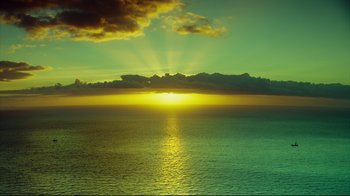 Movie still from “In the Heart of the Sea” (2015), directed by Ron Howard – The sun is setting over the ocean with the sky in the background; Extreme Wide shot, High angle