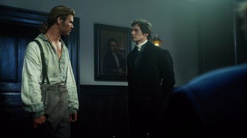 Movie still from “In the Heart of the Sea” (2015), directed by Ron Howard – Two men standing next to each other in front of a painting; Medium shot, Over the shoulder angle