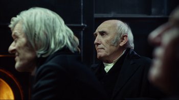 Movie still from “In the Heart of the Sea” (2015), directed by Ron Howard – An older man in a black suit and white shirt looking into a mirror; Close Up shot, Over the shoulder angle