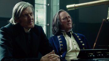 Movie still from “In the Heart of the Sea” (2015), directed by Ron Howard – Two men sitting next to each other at a table; Medium shot, Low angle