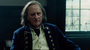 Movie still from “In the Heart of the Sea” (2015), directed by Ron Howard – An older man wearing a blue jacket and a white shirt; Close Up shot, Over the shoulder angle