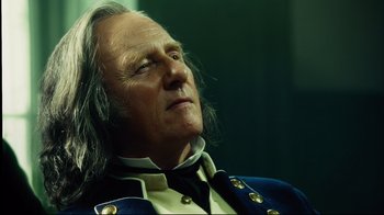 Movie still from “In the Heart of the Sea” (2015), directed by Ron Howard – An old man with long hair and a beard wearing a military uniform; Close Up shot, Low angle