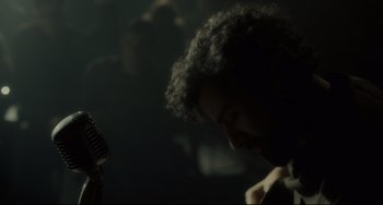 Movie still from “Inside Llewyn Davis” (2013), directed by Ethan Coen – A man with curly hair is looking at a hair brush; Close Up shot, Over the shoulder angle