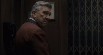 Movie still from “Inside Llewyn Davis” (2013), directed by Ethan Coen – An older man wearing a suit and tie; Close Up shot, Over the shoulder angle