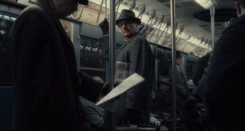 Movie still from “Inside Llewyn Davis” (2013), directed by Ethan Coen – A man in a hat and glasses on a bus; Medium shot, Over the shoulder angle