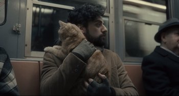 Movie still from “Inside Llewyn Davis” (2013), directed by Ethan Coen – A man holding a cat on a train; Close Up shot, Over the shoulder angle