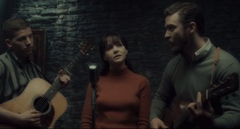 Movie still from “Inside Llewyn Davis” (2013), directed by Ethan Coen – A man and a woman singing into a microphone while another man plays a guitar; Medium shot, High angle