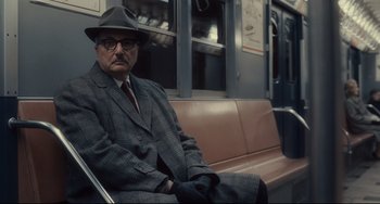 Movie still from “Inside Llewyn Davis” (2013), directed by Ethan Coen – An older man sitting on a bench on a train; Medium shot, High angle