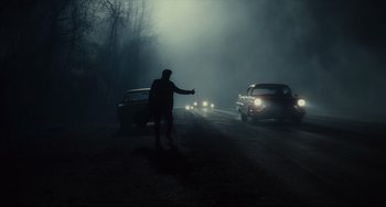 Movie still from “Inside Llewyn Davis” (2013), directed by Ethan Coen – A man is directing traffic on a foggy night; Wide shot, Low angle