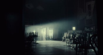 Movie still from “Inside Llewyn Davis” (2013), directed by Ethan Coen – A room filled with lots of chairs in the middle of a room; Extreme Wide shot, Low angle